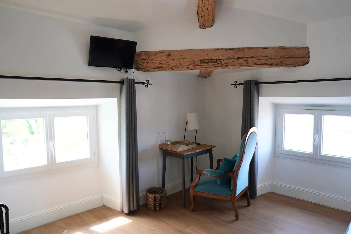 Arbeitsbereich mit blauem Samtsessel und TV unter Sichtbalken des Komfort-Gartenzimmers, Hotel Savel Ruoms
