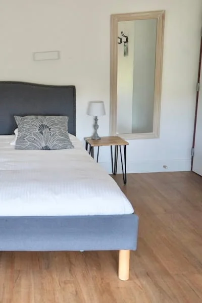 Doppelbett mit Kopfteil und Spiegel des klimatisierten Komfort-Gartenzimmers im Hotel Savel Ruoms
