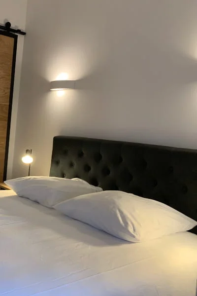 Lit capitonné avec applique murale de la Chambre Confort solo à l'Hôtel Savel de Ruoms en Ardèche