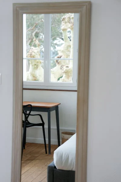 Reflet dans le miroir du bureau et de la fenêtre donnant sur le jardin de la Chambre Confort solo à l'Hôtel Savel de Ruoms