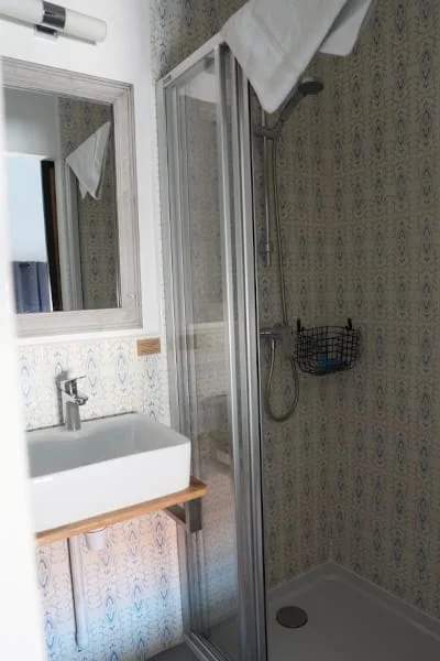 Salle de bain avec douche et carrelage décoratif de la Chambre Confort solo à l'Hôtel Savel de Ruoms en Ardèche