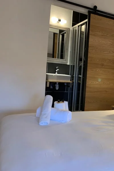 Serviettes et porte coulissante en bois de la Chambre Confort solo à l'Hôtel Savel de Ruoms