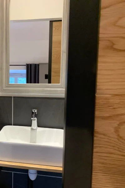 Vasque et miroir de la salle de bain avec porte coulissante de la Chambre Confort solo à l'Hôtel Savel Ruoms