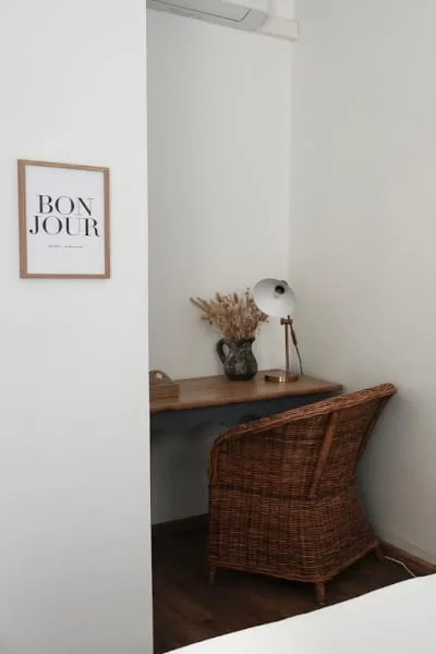 Coin bureau avec fauteuil en rotin de la chambre indépendante climatisée à l'Hôtel Savel à Ruoms