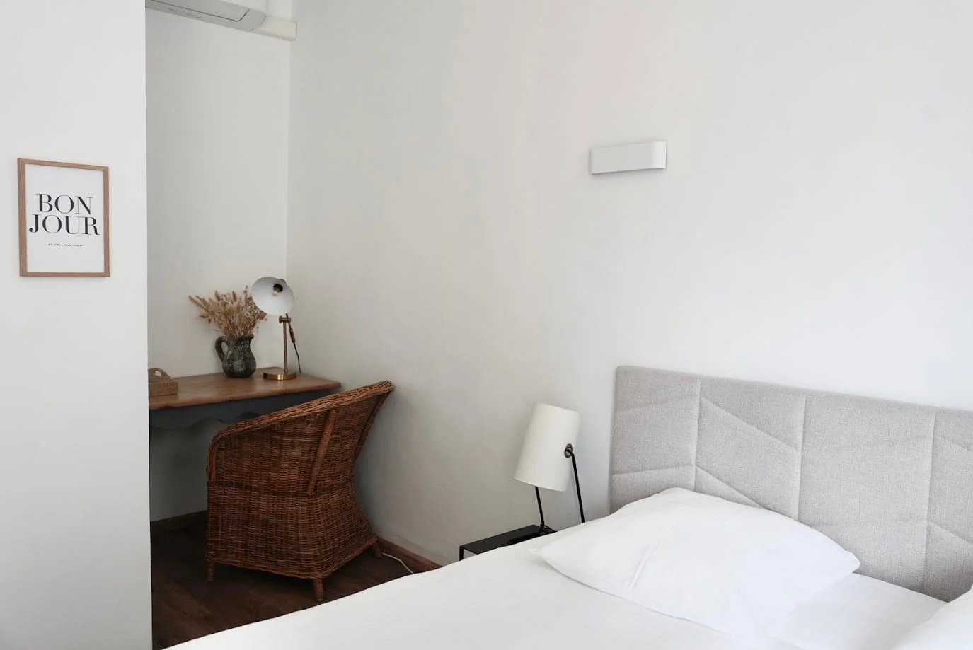 Lit double, bureau et fauteuil en rotin de la chambre indépendante climatisée à l'Hôtel Savel à Ruoms en Ardèche