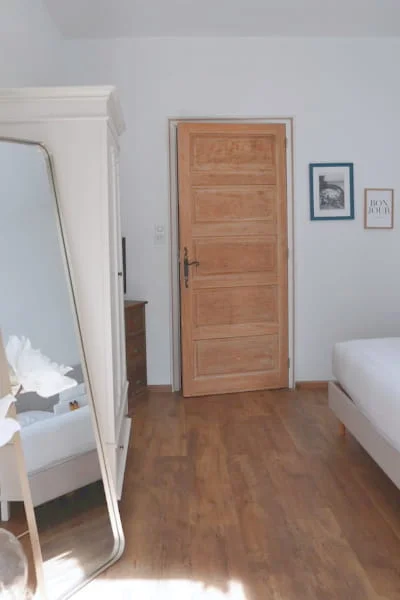 Chambre indépendante avec parquet, miroir et porte en bois naturel à l'Hôtel Savel à Ruoms en Ardèche