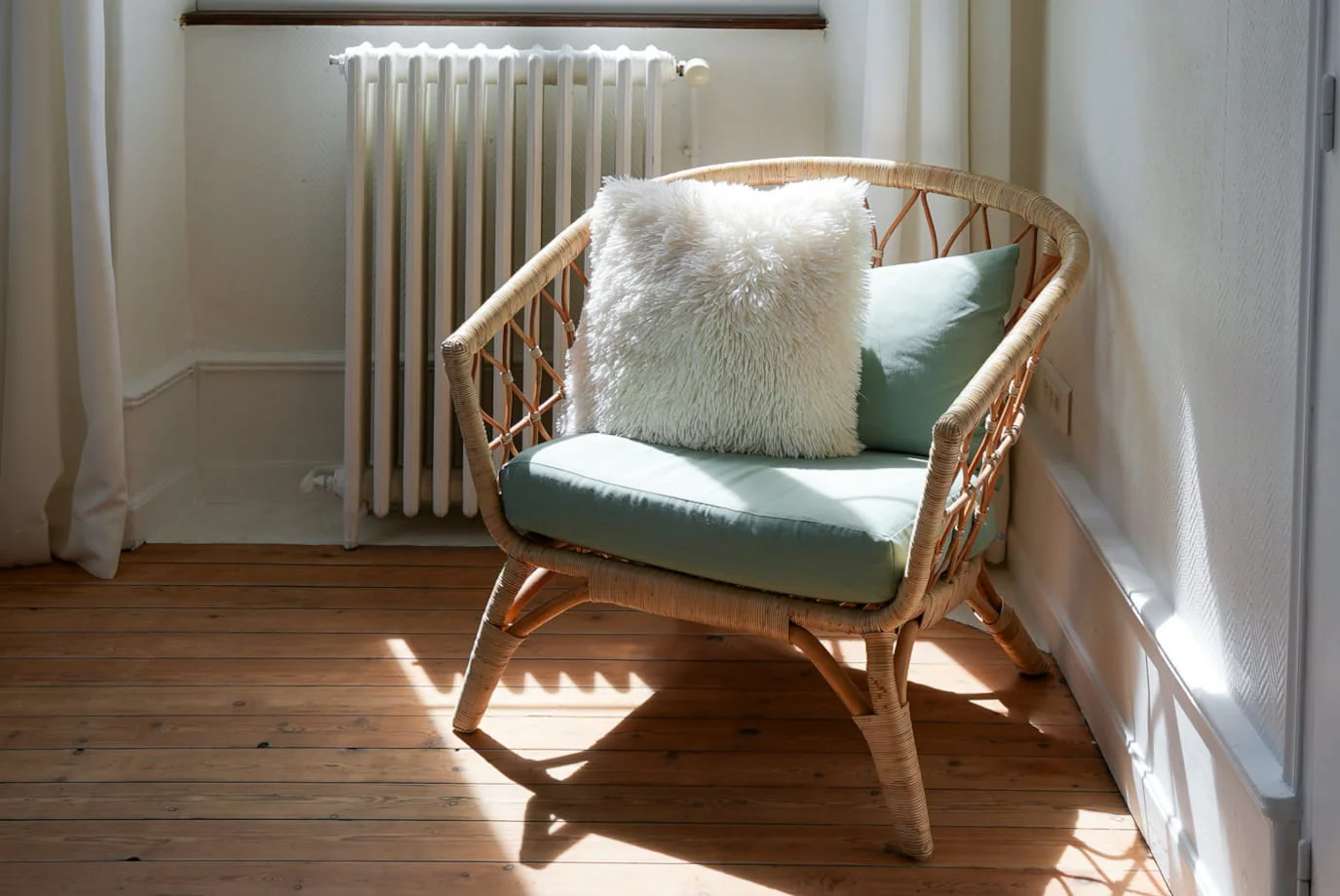 Fauteuil en rotin lumineux dans le coin lecture de la Chambre Premium à l'Hôtel Savel de Ruoms en Ardèche