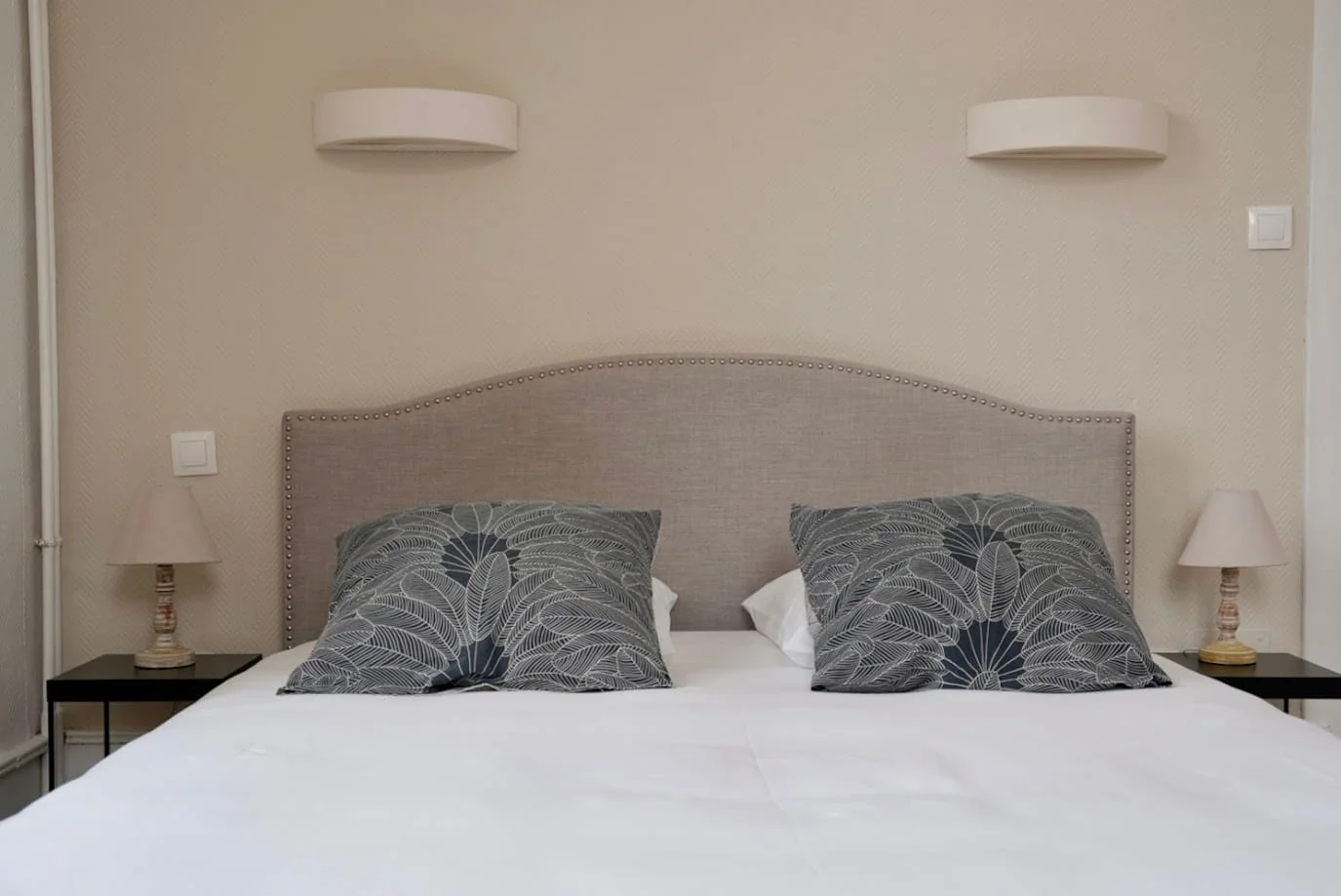 Lit capitonné avec appliques et parquet de la Chambre Premium de charme à l'Hôtel Savel de Ruoms