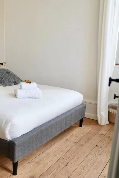 Lit confortable avec serviettes et parquet de la Chambre Premium à l'Hôtel Savel de Ruoms