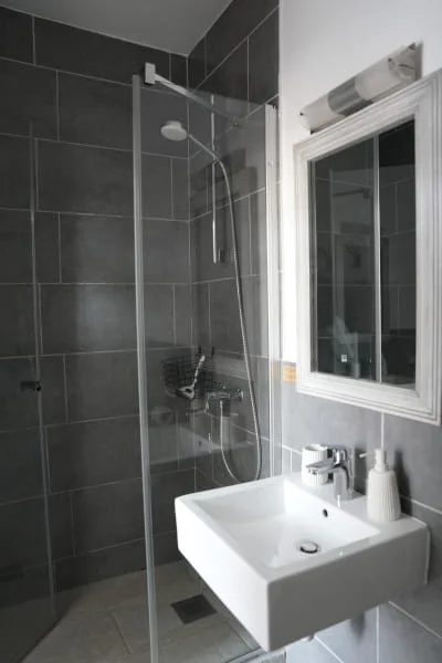 Salle de bain moderne avec douche à l'italienne et carrelage gris anthracite, chambre luxe de l'Hôtel Savel à Ruoms en Ardèche