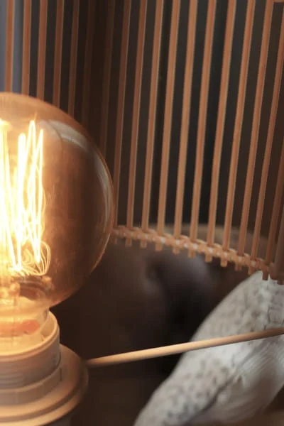 Détail d'ambiance de la chambre luxe avec lampe vintage ampoule Edison et tête de lit en lattes de bois, Hôtel Savel à Ruoms Ardèche