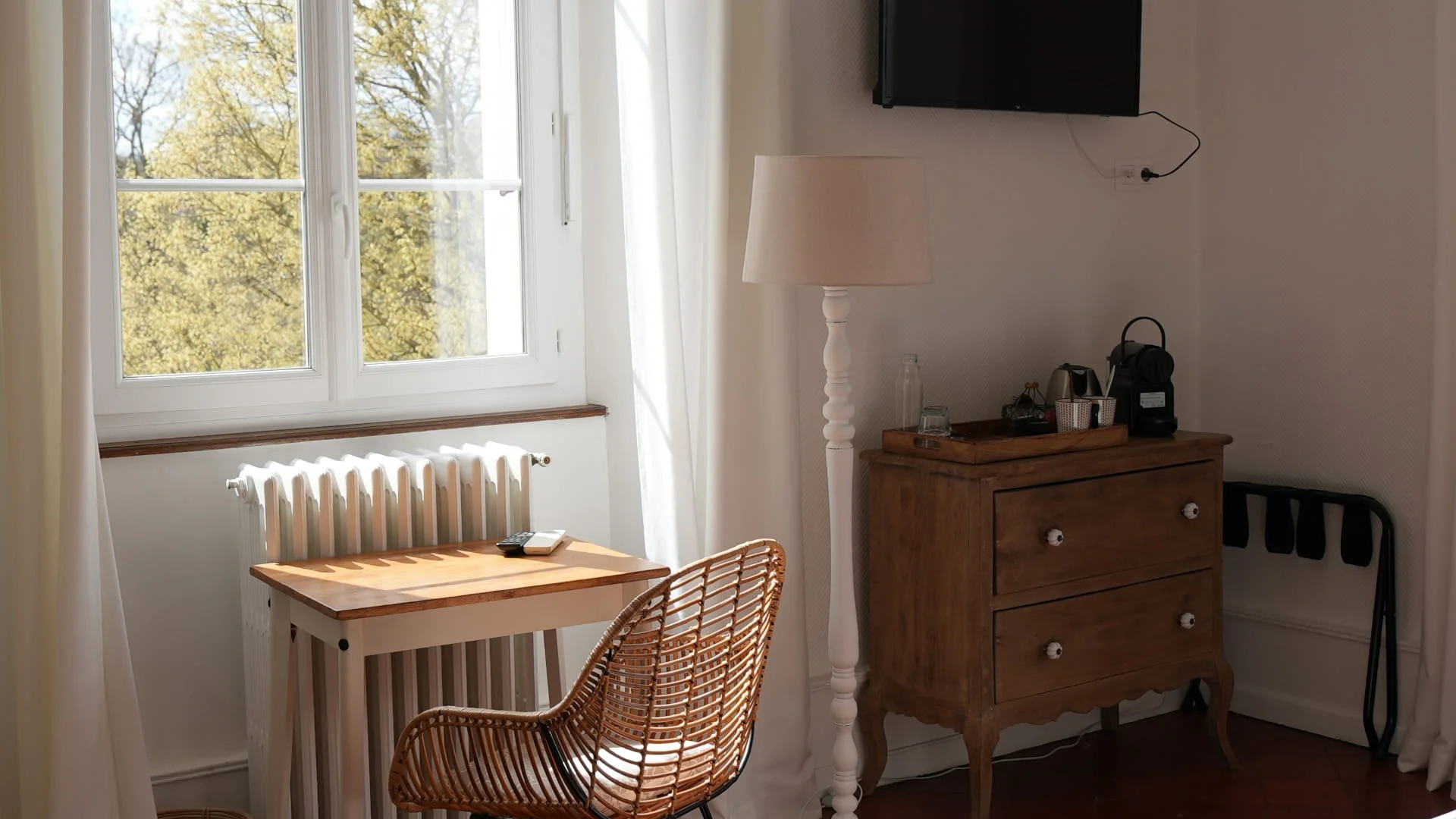 Coin bureau avec chaise en rotin, commode ancienne, machine à café Nespresso et télévision murale, Grande chambre à Ruoms de l'Hôtel Savel en Ardèche