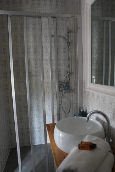 Douche moderne et ambiance élégante de la chambre Confort lits jumeaux climatisée à l'Hôtel Savel à Ruoms