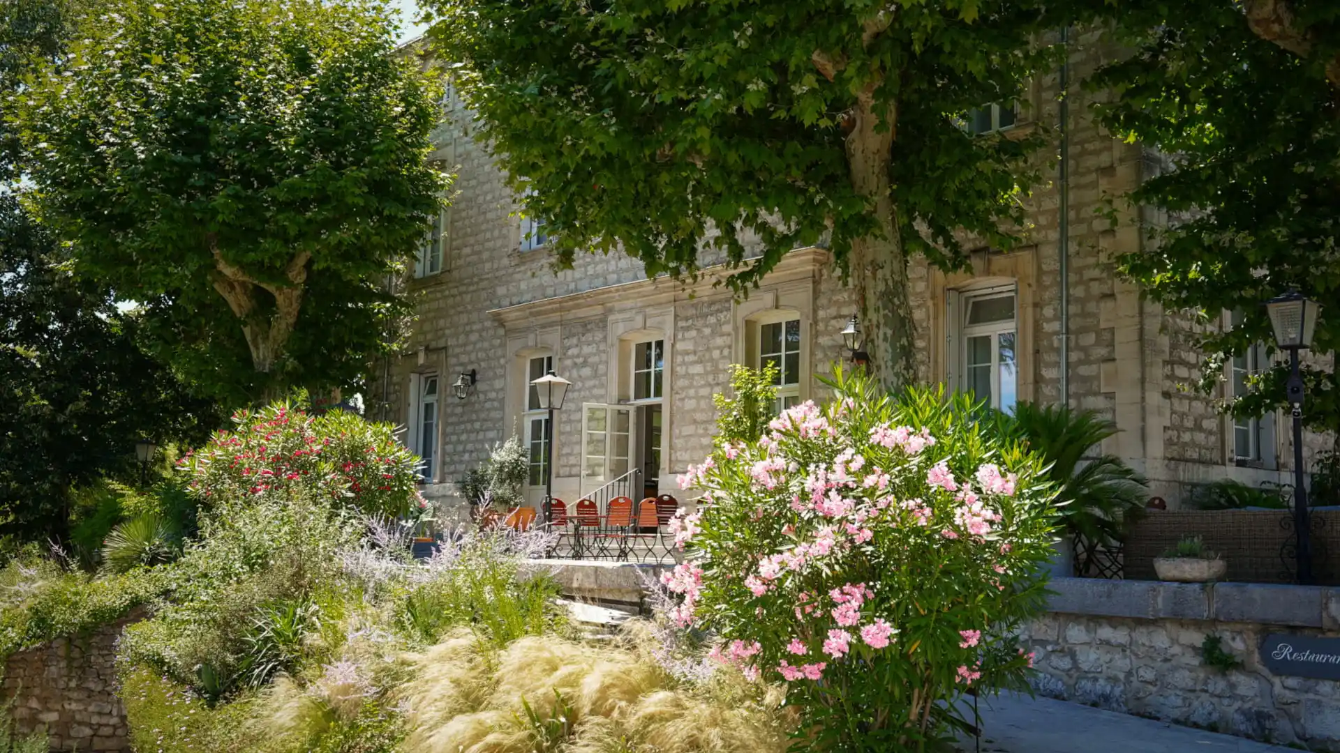 Fassade des Hôtel Savel in Ruoms, umgeben von seinem blühenden Garten in der südlichen Ardèche