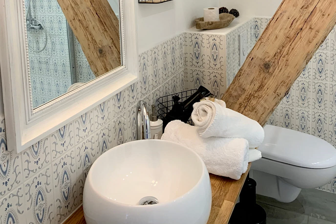 Bathroom with round basin, decorative tiles and exposed beams in the Comfort Suite at Hotel Savel Ruoms