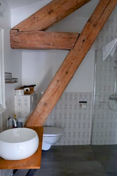 Salle de bain complète avec vasque, douche et poutres apparentes de la Suite Confort à l'Hôtel Savel Ruoms
